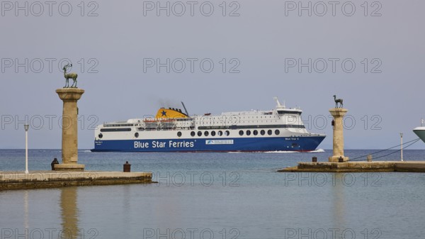 Ferry boat sailing between columns with statues on blue sea, Deer statue, Deer statue, Mandraki
