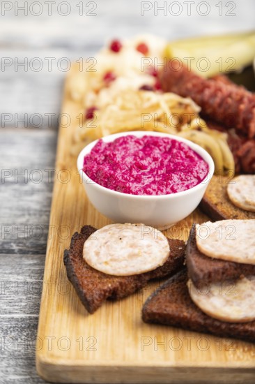 Set of snacks: sausages, toast, sauerkraut, marinated onion and cucumber, baked potato on a cutting