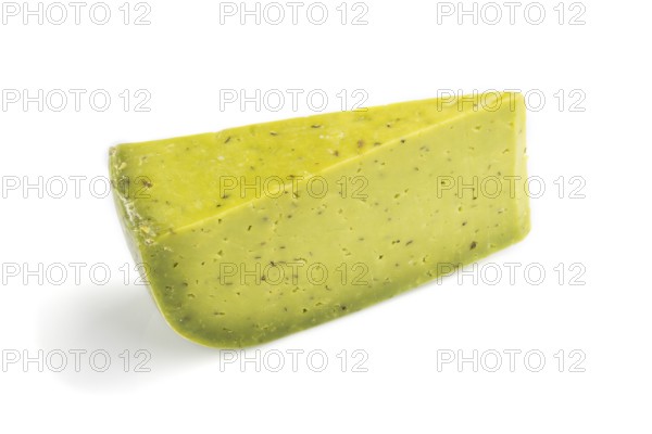 Piece of green cheese with basil isolated on white background. Side view, close up