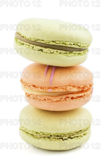 Orange and green macarons or macaroons cakes isolated on white background. side view, close up,