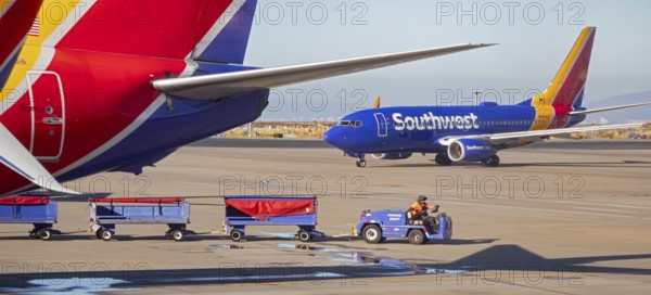 Oakland, California, A worker pulls bagge carts around Southwest Airlines planes at Oakland