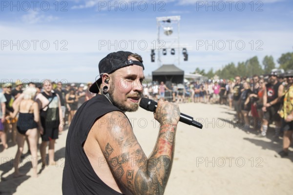 Matthias Engst, singer of the band Engst on the beach in front of the Becks Beach Stage at the