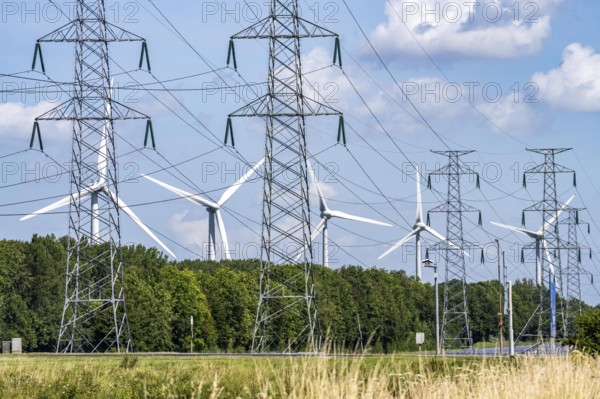 High-voltage power line route, with a wind farm behind it, in the harbour area of Vlissingen-Oost,
