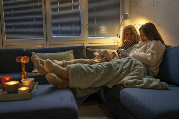 Symbolic image energy saving, cold winter, energy crisis, cold flat, mother and daughter lying on