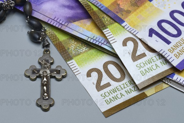 Crucifix and banknotes, Swiss francs, church and money