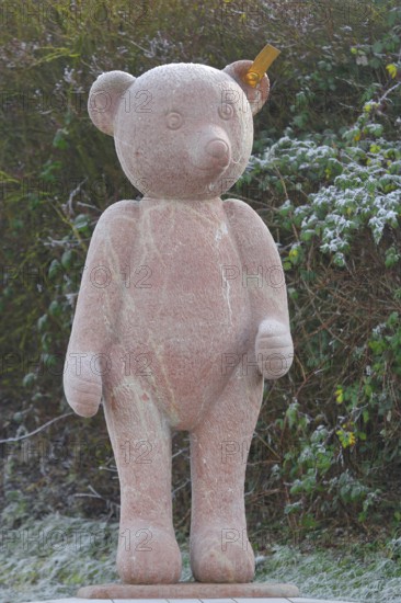 Red Steiff bear figurine, stone sculpture with trademark button in ear, emblem, brand name,