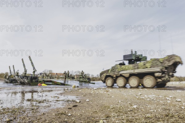 A Pandur II tank navigates the Bundeswehr's Amphibie M3 floating high-speed bridge in the Elbe as
