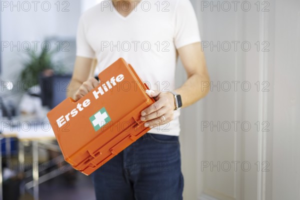 Occupational safety. A man holds a first aid kit in an office in Berlin, 09/08/2024