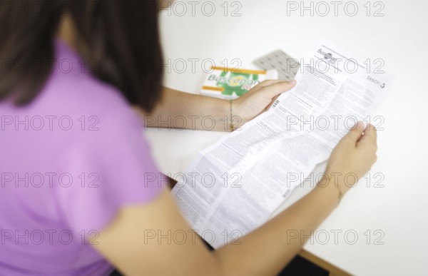 A woman reads an instruction leaflet for a medicine. Berlin, 08.08.2024