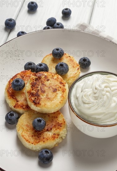 Cottage cheese pancakes, with blueberries, breakfast, on a white wooden table, no people, top view