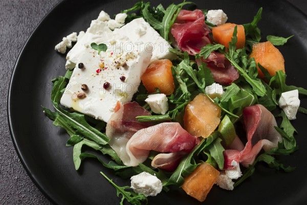 Salad, melon with prosciutto, arugula, and cheese, summer salad, vegetarian, homemade, no people