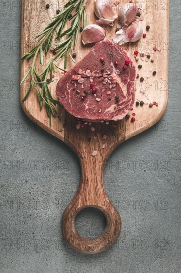 Fresh, raw rib eye steak, on a chopping board, top view, no people