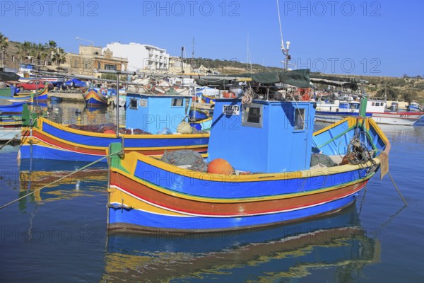 Colourful traditional fishing boats called luzzu in the harbour at Marsaxlokk, Malta, Europe
