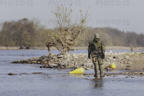 A soldier stands by the Elbe, taken as part of the military exercise 'Wettiner Schwert' with German