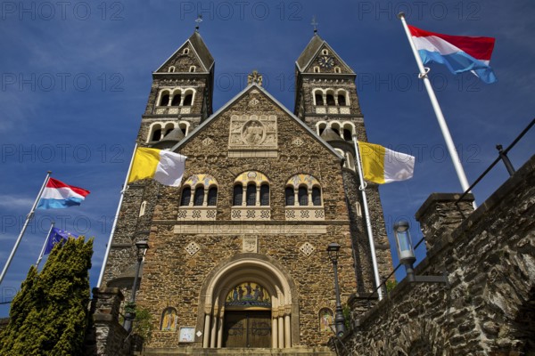Roman Catholic parish church in Clerf with church flag and Luxembourg flag, Duchy of Luxembourg