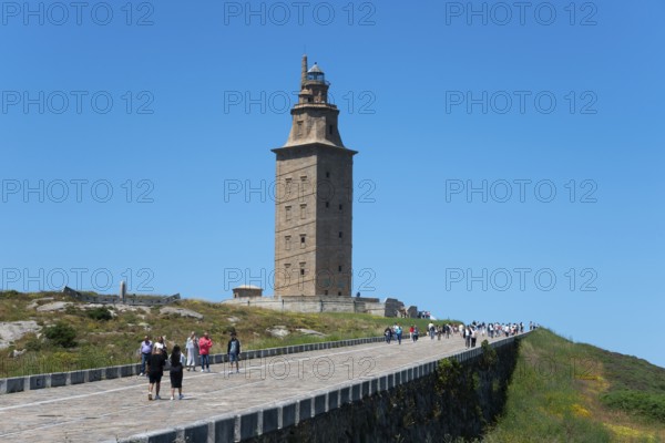 Lighthouse with many visitors on the way there, in sunny weather and blue sky, Torre de Hércules,