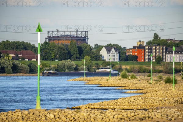 Cargo ship at low water on the Rhine near Duisburg-Homberg, view of Duisburg-Laar, houses on