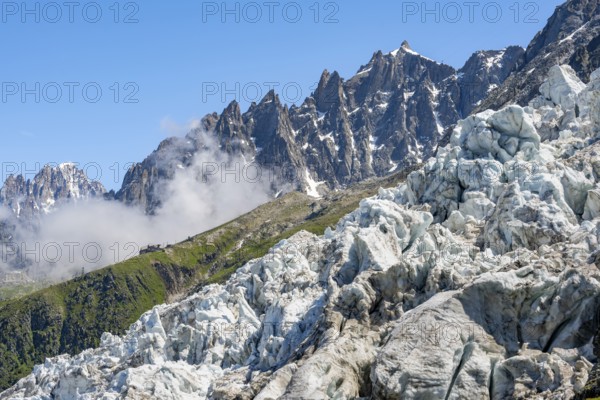 Glacier ice of the Glacier des Bossons, pointed mountain peaks in the background, Chamonix,
