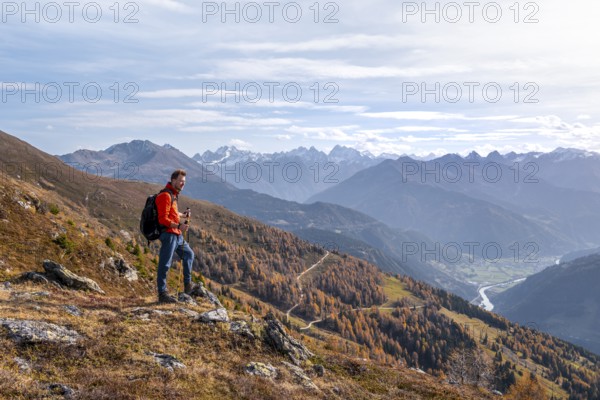 Mountaineer in front of mountain panorama, view from Venet into the Upper Inn Valley, in autumn,