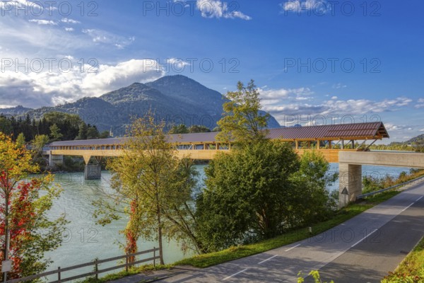 Landscape view of a wooden bridge over a river surrounded by autumnal nature and mountains, Inn