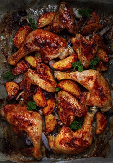 Roast chicken legs with potatoes and onions in the oven, homemade. No people