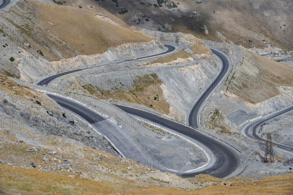 Winding roads on the Pamir Highway, mountain road through an eroded mountain landscape, Kyrgyzstan,