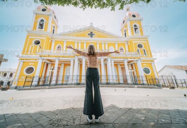 Tourist woman spreading arms in front of a cathedral in a tourist square. Happy tourist in a