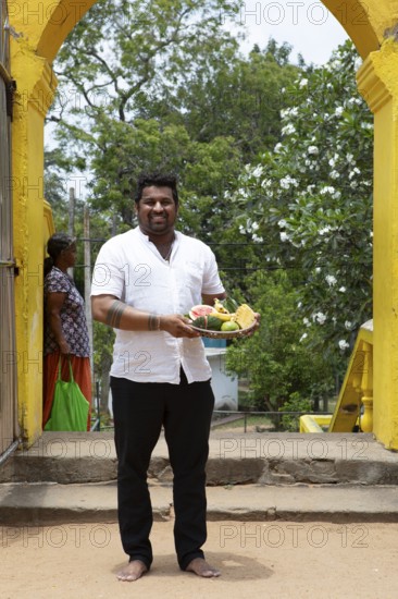 Sri Lankan man, 33 years old, with offerings at the Buddhist temple Ruhunu Maha Kataragama