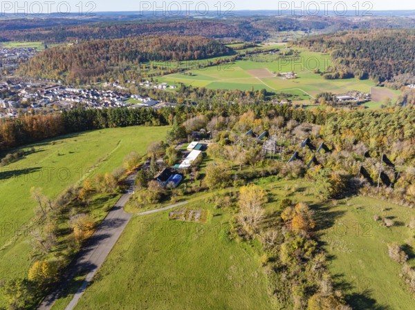 Wide landscape with fields, forests and a small village surrounded by autumnal trees, high ropes