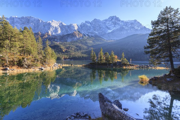 Steep mountains reflected in lake, evening light, autumn, Eibsee lake, Zugspitze, Bavaria, Germany,