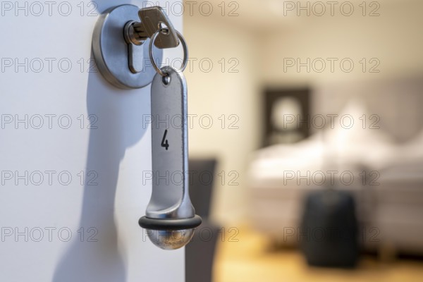 Symbolic image of a hotel, key inserted in the door of a hotel room, analogue lock