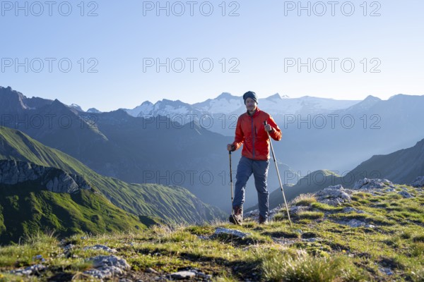Hiker enjoying the mountain panorama in the morning, Venediger group, behind Dreiherrenkopf,
