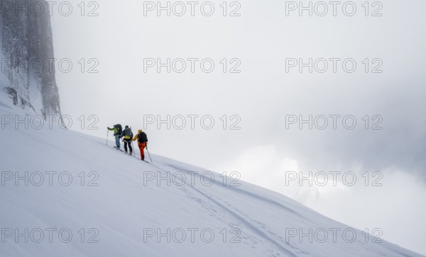 Dramatic atmosphere, Ski tourers, Snowy mountain landscape, Bernese Alps, Bernese Oberland,