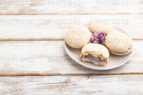 Meringues cakes on a white wooden background. Side view, copy space, close up