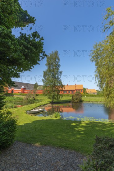 Farm building of Hesselagergaard Manor with park, lake, rowing boat, Fyn, Fyn Island, Denmark,