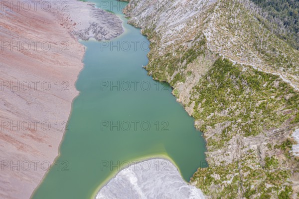 Dead trees, crater rim of Chaiten volcano, colored rock, small lake, aerial view, Park Pumalin,