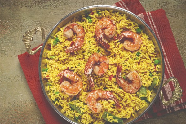 Rice with saffron and shrimp, in a frying pan, paella with shrimp, top view, homemade, no people