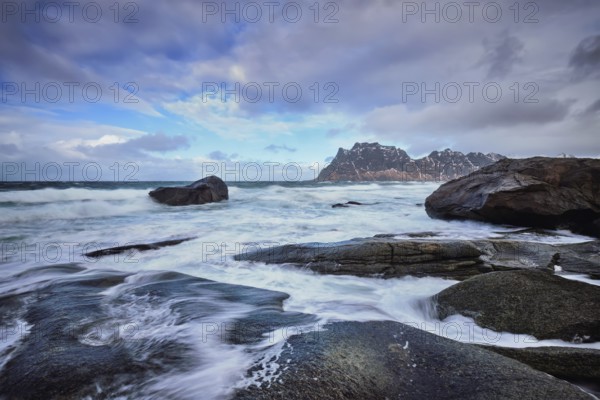Rocks on beach of fjord of Norwegian sea in winter with snow. Utakliev beach, Lofoten islands,