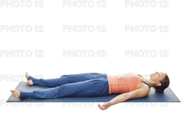 Woman relaxes in yoga asana Savasana, corpse pose isolated on white