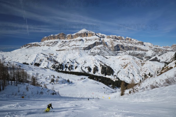 View of a ski resort piste with people skiing in Dolomites in Italy. Ski area Arabba. Arabba,