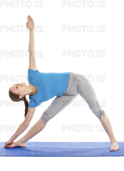 Yoga, young beautiful slender woman yoga instructor doing Triangle asana pose (utthita trikonasana)