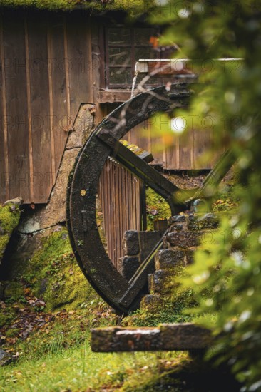 Historic Streinbrunnen fountain with mill wheel in autumn, Bad Wildbad, Kurpark, Black Forest,