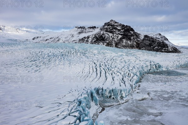 Snow-covered icebergs in the Fjallsarlon glacier lagoon, with the Öraefajökull glacier behind,