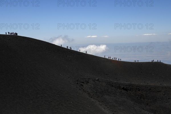 Hikers in the crater landscape of the volcano Etna, summit region, province of Catania, Sicily,