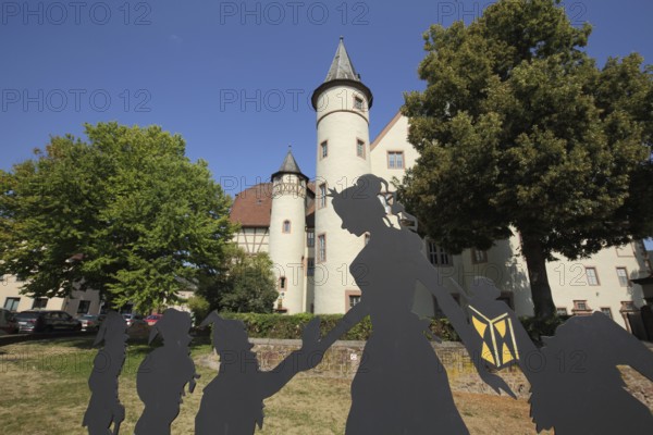 Figures from the fairy tale Snow White and the Seven Dwarfs in front of the late Gothic castle