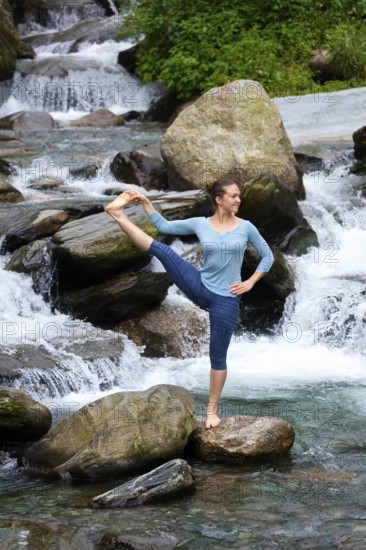 Yoga outdoors, woman doing Ashtanga Vinyasa Yoga balance asana Utthita Hasta Padangushthasana,