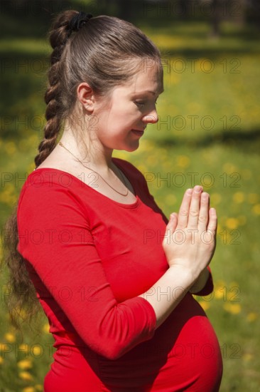 Pregnancy yoga exercise, pregnant woman doing asana Tadasana namaste -Mountain pose with salutation