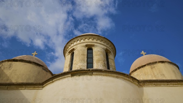 Towers with cross, round tower, ochre building, wide angle, blue sky with white clouds, Odigitrias