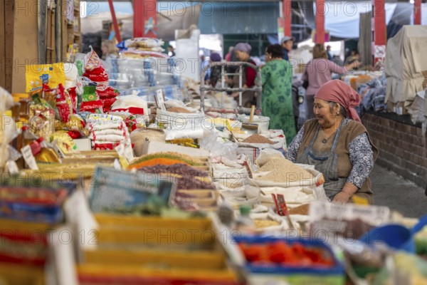 Traditional woman selling spices, flour and food, market stall at Osh Bazaar, Bishkek, Kyrgyzstan,