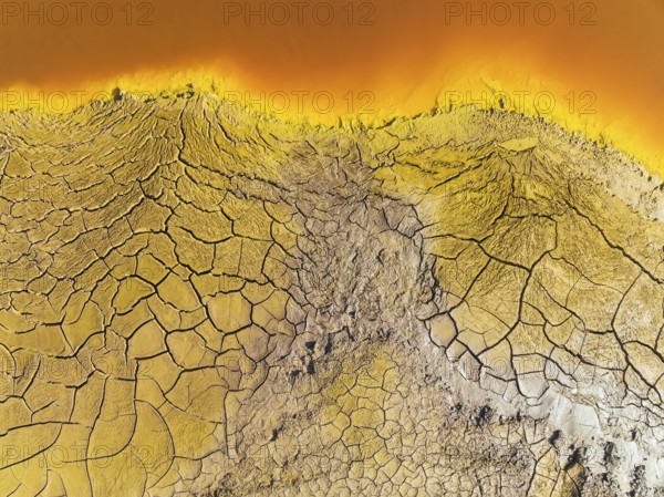 Cracked earth at the bank of the Rio Tinto (Red river) with its deep reddish hue due to oxidised
